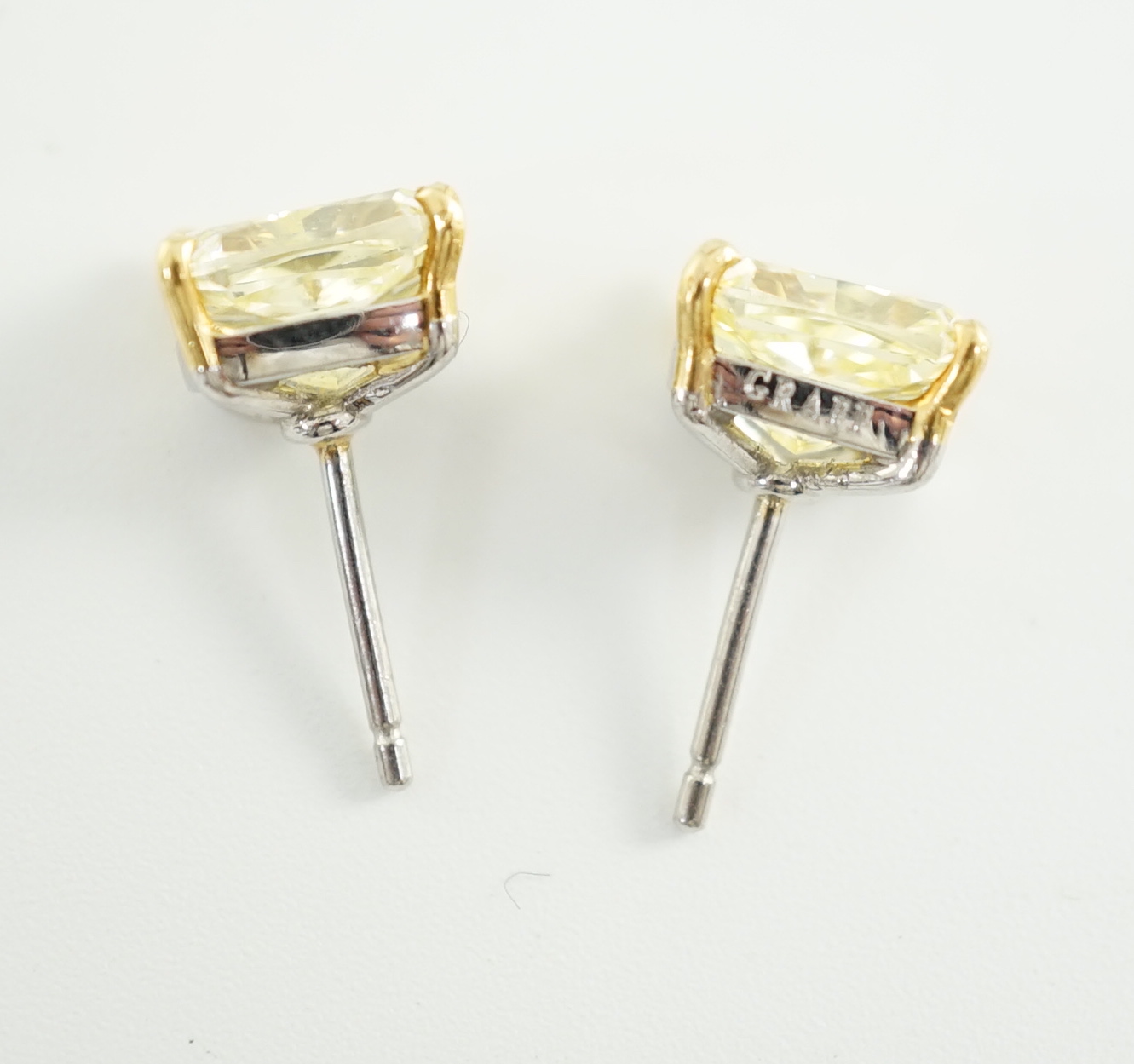 A fine pair of Graf platinum and 18ct white gold set cushion modified brilliant cut natural fancy yellow diamond ear studs